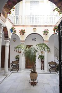un gran pasillo con una maceta en un edificio en La Casa de los Faroles, en Córdoba