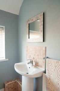 een badkamer met een wastafel en een spiegel bij Cottage Lawn Apartment in Enniskillen