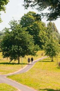 two people walking down a path in a park at Cottage Lawn Apartment in Enniskillen