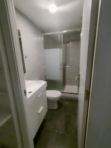 La salle de bains blanche est pourvue d'une douche et de toilettes. dans l'établissement San Centro IFEMA Wizink Metropolitano Airport Apartments, à Madrid