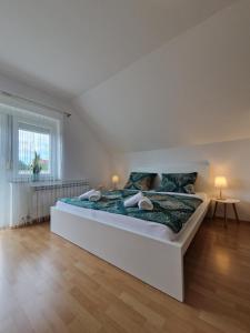 a white bedroom with a large bed in a room at Green House Apartment in Pivka