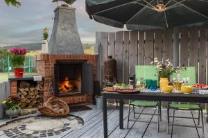 eine Terrasse mit einem Kamin und einem Tisch mit Speisen in der Unterkunft Stara Mleczarnia in Tylicz