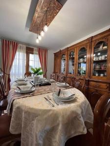 une salle à manger avec une table, des assiettes et des ustensiles de cuisine dans l'établissement Espectacular Casona Montañesa, à Ibio