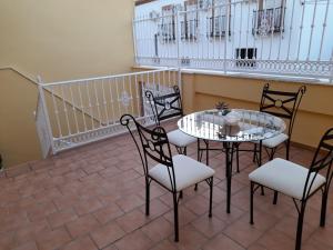 a patio with a table and chairs on a balcony at Puerta de la Bética in Mengibar