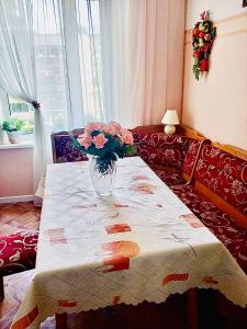un vase de fleurs sur une table dans le salon dans l'établissement Комната с лоджией у Татьяны, à Jurmala