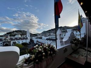 uma vista para a cidade a partir de uma varanda com flores em Plaza Grande Hotel em Quito