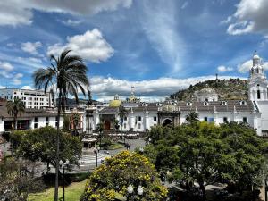 ein großes Gebäude mit einer Palme davor in der Unterkunft Plaza Grande Hotel in Quito