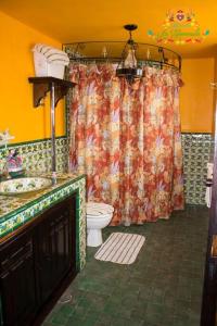 a bathroom with a toilet and a shower curtain at Hacienda La Gioconda in Nopala