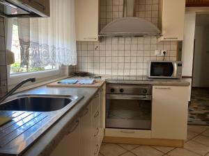 a kitchen with a sink and a microwave at 7 Flower Street Apartment in Šempeter pri Gorici