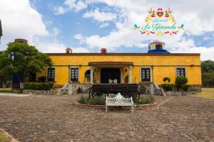 Nopala的住宿－Hacienda La Gioconda，黄色的建筑,上面有标志