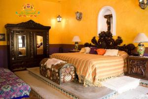 1 dormitorio con 2 camas y paredes de color naranja en Hacienda La Gioconda, en Nopala
