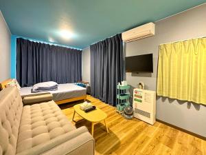 小樽市にあるPIER6 Otaruのソファ、ベッド、テレビが備わる客室です。
