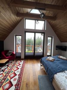 Un dormitorio con una cama y una ventana grande. en Domek MAGURA, en Dzianisz