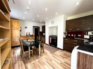 een keuken met een zwarte tafel en houten kasten bij High Gables Apartment 2 in Paignton