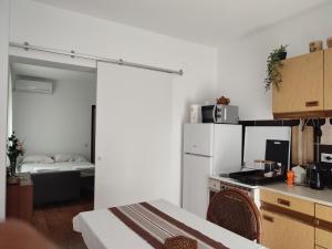 a kitchen with a white refrigerator and a bed at MILA city center-free parking in Vranje
