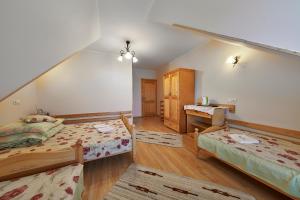 sypialnia na poddaszu z 2 łóżkami i biurkiem w obiekcie Pokoje Cichy Kącik w Zakopanem