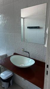 bagno con lavandino, servizi igienici e specchio di Pousada Mar & Sol a Tutóia