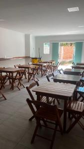 a group of tables and chairs in a room at Pousada Mar & Sol in Tutóia