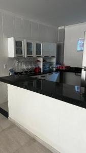 a kitchen with a black counter top in a room at Pousada Mar & Sol in Tutóia
