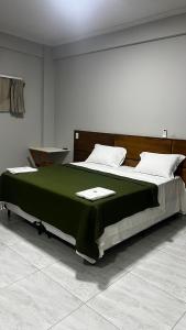 una camera da letto con un grande letto con una coperta verde di Pousada Mar & Sol a Tutóia
