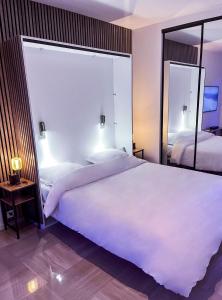 sypialnia z dużym białym łóżkiem i lustrem w obiekcie Promenade-des-anglais-front-sea w Nicei
