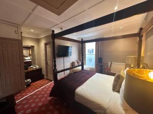 um quarto de hotel com uma cama grande num quarto em The Tudor Hotel em Bridgwater
