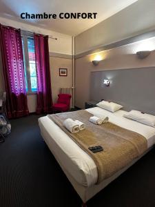 a bedroom with a large bed with towels on it at Hôtel Terminus - Pizzeria Pizz'a gogo - salle de sport - face à la gare in Lons-le-Saunier