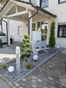 a bench in front of a house with trees at Ferienwohnung DG in Altenkunstadt