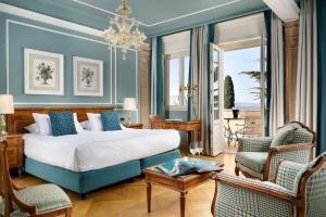 a bedroom with a bed and a living room at Villa Cortine Palace Hotel in Sirmione