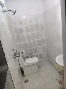 uma casa de banho com um WC e um lavatório em Apna Guest House Dehradun em Dehradun
