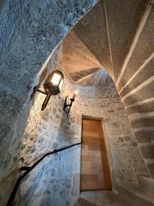 eine Treppe mit einem Licht an einer Steinmauer in der Unterkunft Château de la Borde à Ussel in Ussel