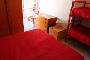 Appartamento Giove في بيبيوني: غرفة نوم بسريرين وخزانة ومكتب