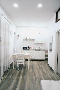 - une cuisine blanche avec une table et des chaises blanches dans l'établissement CASA MONTAGNOLA34 Centro Storico, à Naples