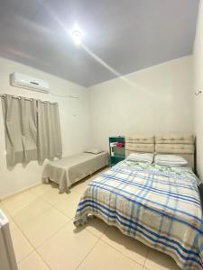 a white bedroom with a bed and a window at Pousada Mineira in Barreirinhas