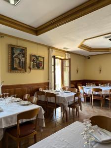 un comedor con mesas y sillas blancas en Hostal Restaurante Boccalino, en León