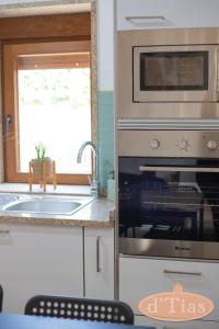 a kitchen with a microwave oven and a sink at Casa das Tias in Baltar