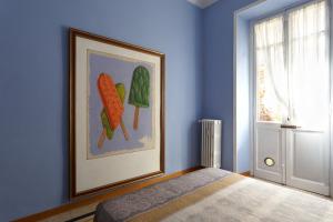 een slaapkamer met een schilderij van wortelen aan de muur bij Vanchiglia Apartment - Torino in Turijn