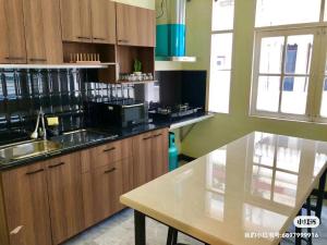 - une cuisine avec des placards en bois et un comptoir dans l'établissement 曼谷自由之家, à Klong Toi