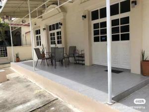 un patio avec des chaises et une table dans un bâtiment dans l'établissement 曼谷自由之家, à Klong Toi