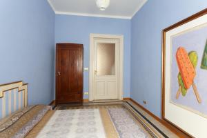 a blue room with two beds and a door at Vanchiglia Apartment - Torino in Turin