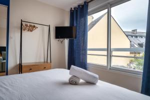 a bedroom with a bed with a tv and a window at Résidence St Marc - L'Art Déco - Centre ville in Quimper