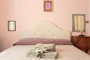 een slaapkamer met een bed met een wit hoofdeinde en een spiegel bij Vanchiglia Apartment - Torino in Turijn +28 foto's