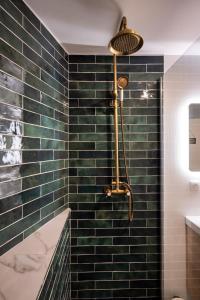 La salle de bains est pourvue d'une douche avec du carrelage vert du métro. dans l'établissement Résidence St Marc - L'Art Déco - Centre ville, à Quimper