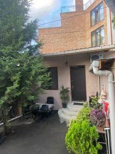 una casa con porche y un edificio en Guest House 27 en Tiflis