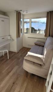 sala de estar con sofá blanco y ventana en Appartement 20m², tout confort, entièrement rénové en Prémanon