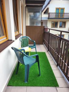 two chairs and a table on a balcony at Apartament ORKAN przy Krupówkach in Zakopane