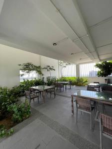 an empty room with tables and chairs and plants at Pavilion Bukit Jalil Revo@Aurora By D'Summer91 in Kuala Lumpur