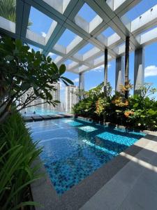 a swimming pool in a building with a glass ceiling at Pavilion Bukit Jalil Revo@Aurora By D'Summer91 in Kuala Lumpur