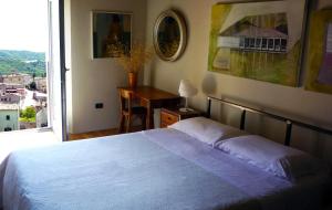 a bedroom with a bed and a desk and a window at Camera con vista in Fossombrone