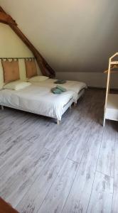 1 dormitorio con 2 camas y suelo de madera en Gîte-Région centre-Sologne 41 proche Lamotte Beuvron, en Nouan-le-Fuzelier
